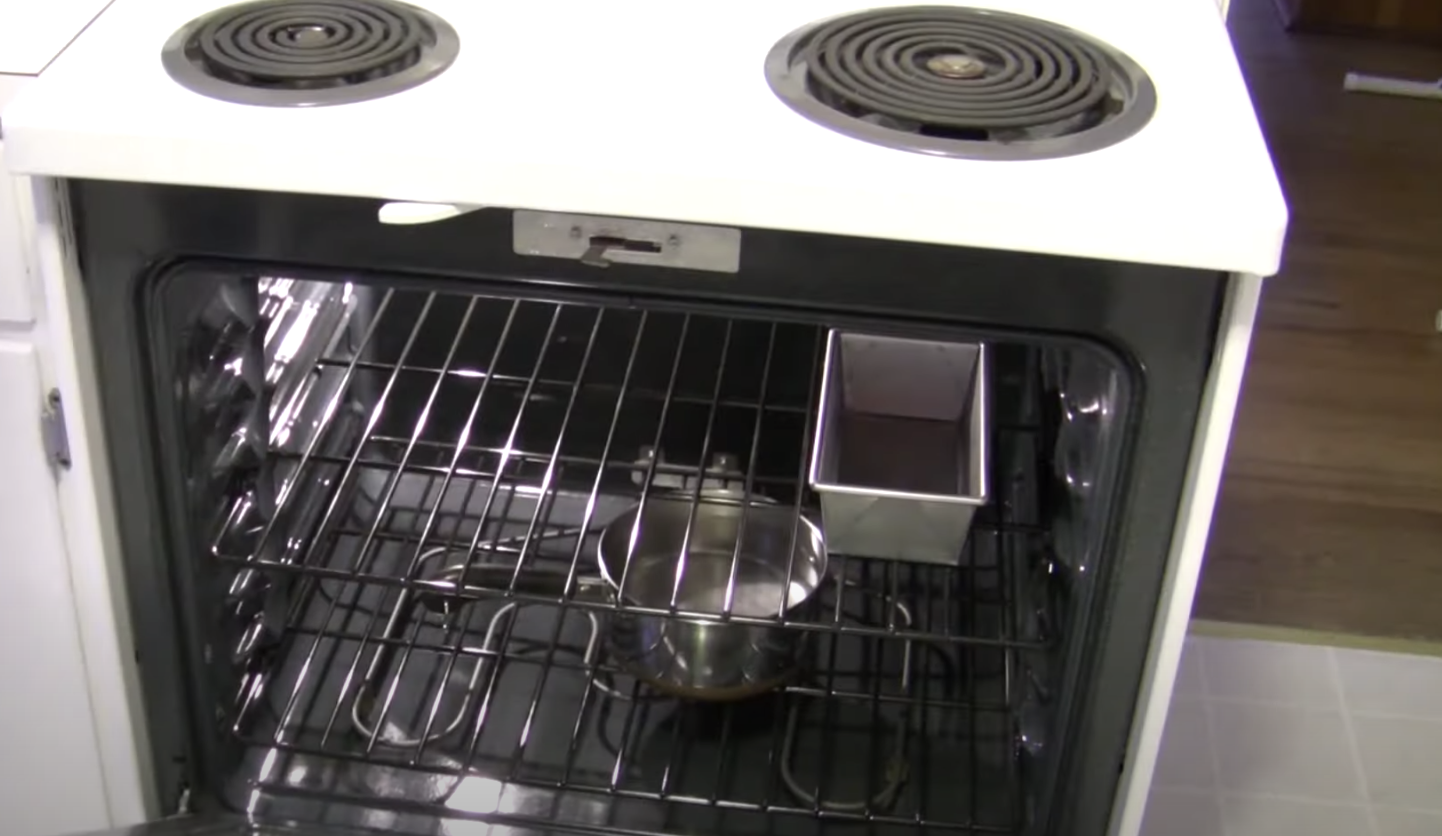 A hot pot of water in the oven below a bread loaf tin