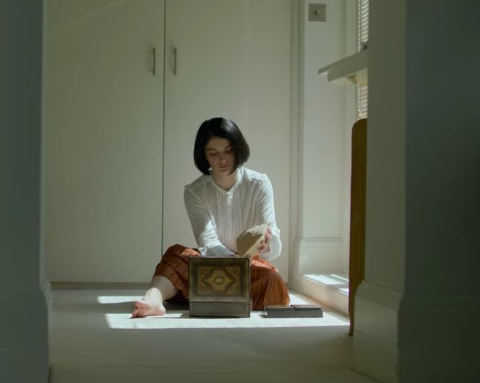 Adele sits in front of a box containing drug paraphernalia 