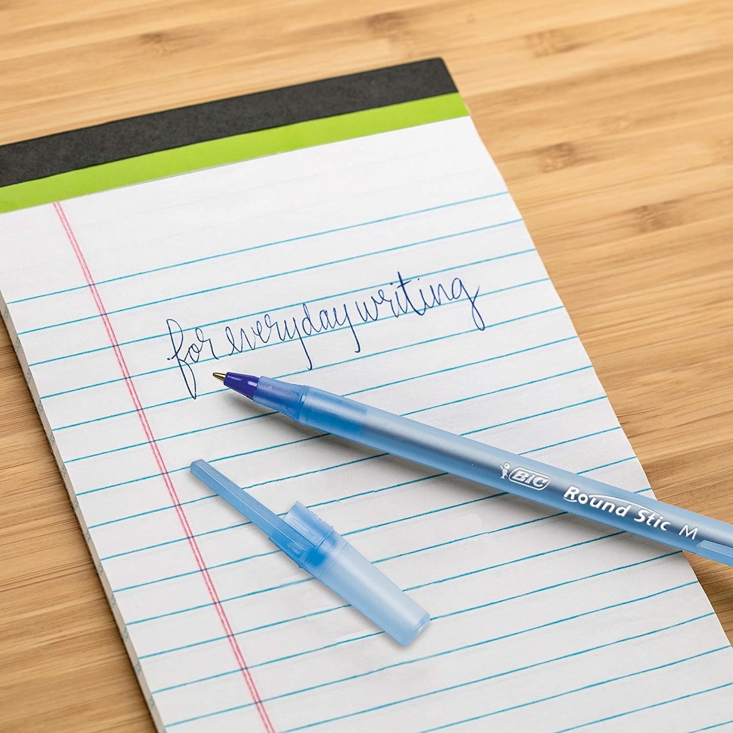 A notepad with an uncapped pen on top