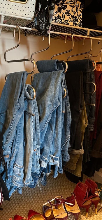 reviewer pic of four of the hangers with lots of jeans on each one