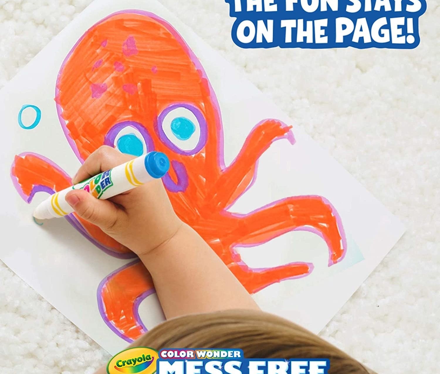 A child&#x27;s hand colouring a picture of an octopus on a paper