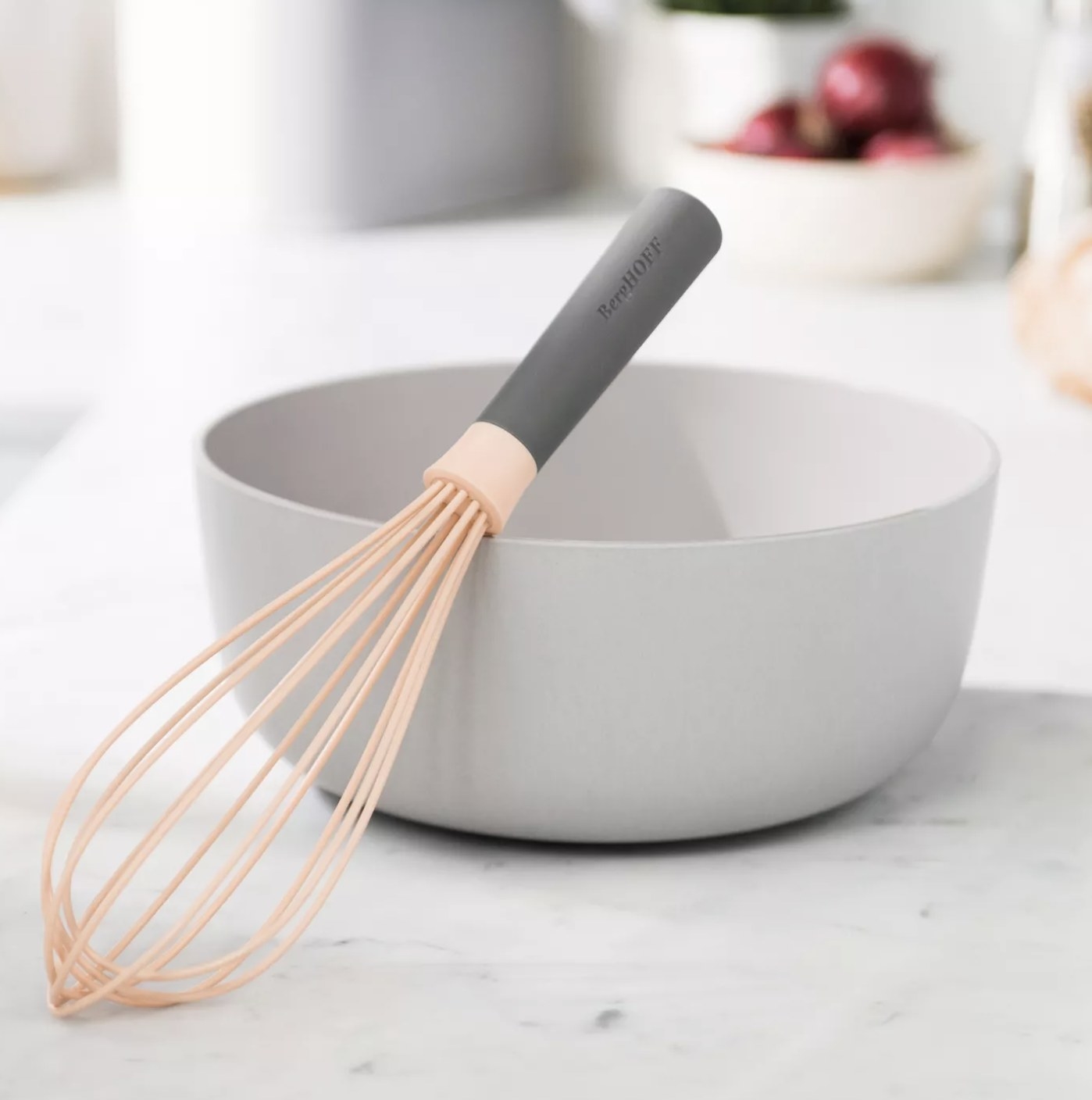 A peach-colored whisk