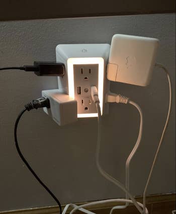 reviewer's charger with several large plugs in it 