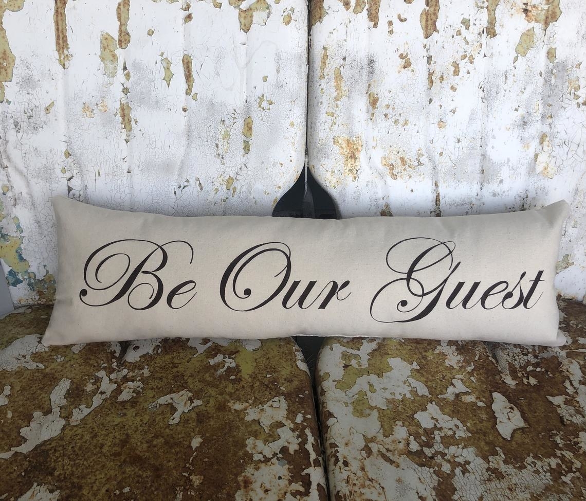 Long pillow that says &quot;Be Our Guest&quot; 