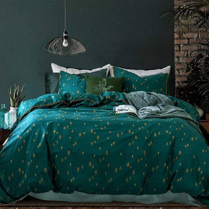 Deep blue-green bedding with gold tree details throughout 