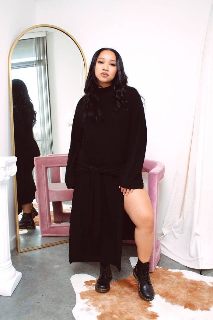 model in long sleeve sweater dress with side slit and tie waist
