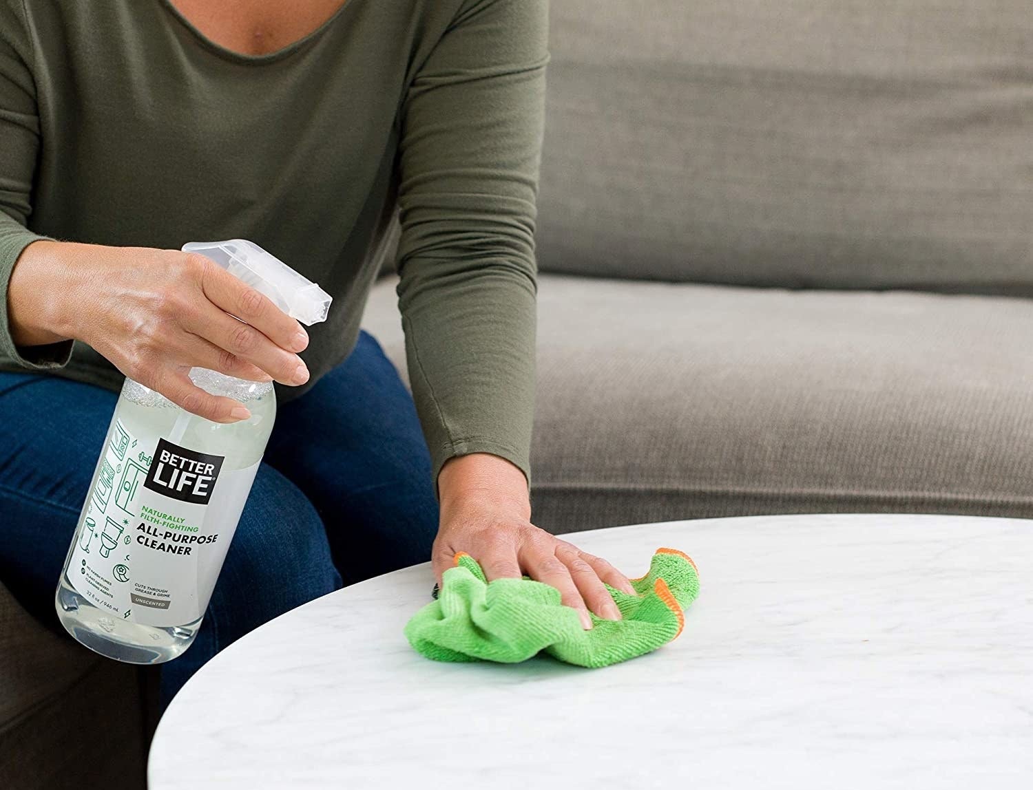 person spraying and wiping table with the all purpose cleaner