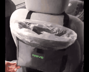 gif of a reviewer tossing an empty bottle into their drive bin which is attached to the back of the driver seat