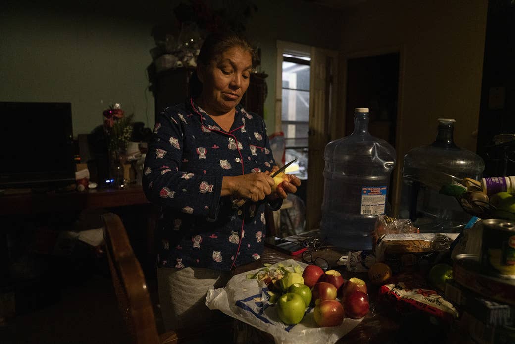 Nohemí peels apples on the dining table at her sister&#x27;s house