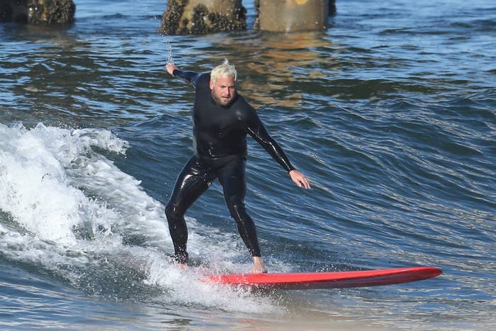 Jonah surfing in a wetsuit