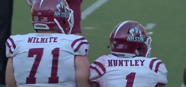 A red helmet with a mustached cowboy mascot with the words &quot;NM STATE&quot; below him