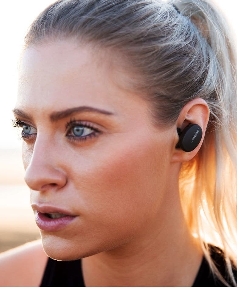 woman wearing black in-ear Bose sport earbuds