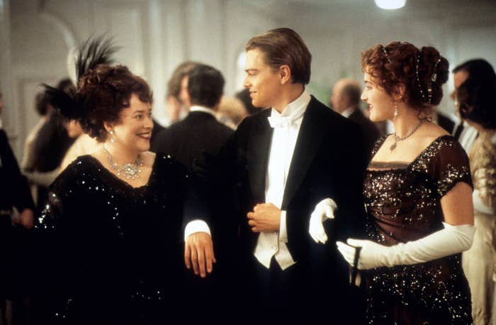 Kathy Bates, Leonardo DiCaprio, and Kate Winslet are arm-in-arm in the film Titanic
