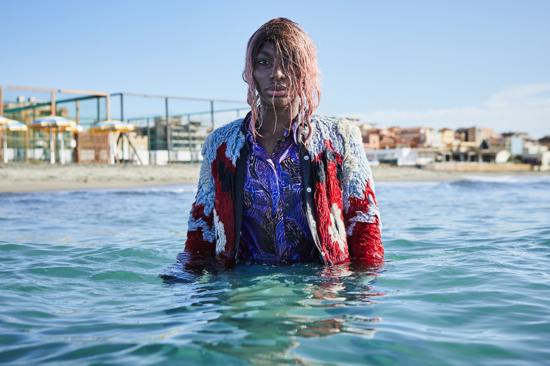 Michaela Coel standing fully clothed in the ocean in I May Destroy You