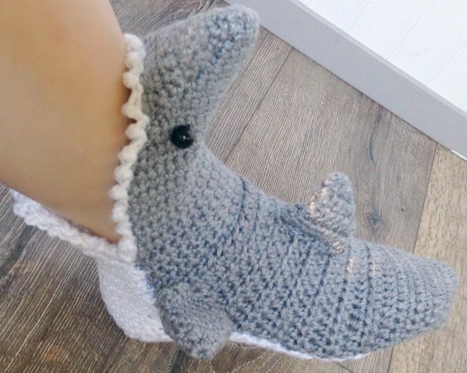person wearing the crochet shark slipper on their foot