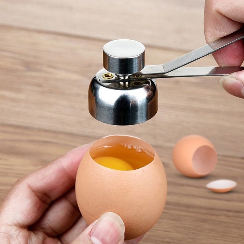 A person using the metal egg scissors