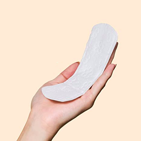 A person holding up one of the panty liners against a soft background