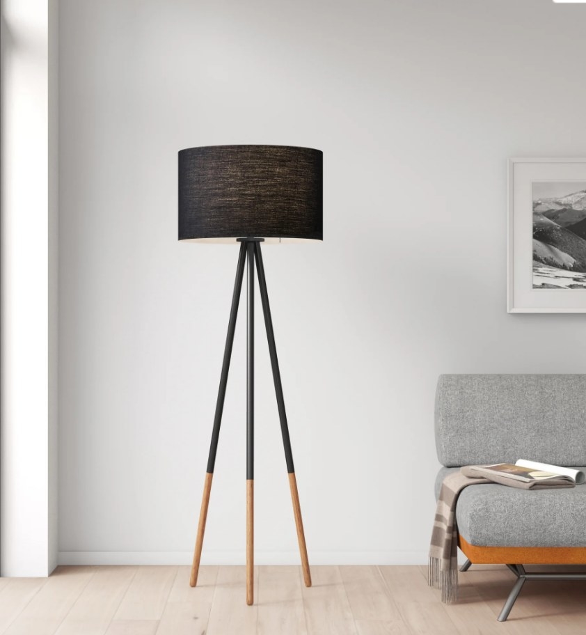 Black tripod floor lamp with black fabric shade and black/wooden legs