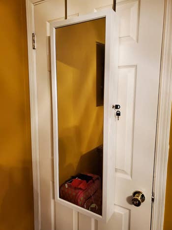 A reviewer photo of the cabinet closed and installed as an over-the-door mirror