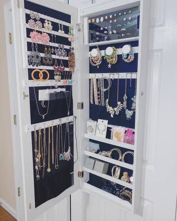 A reviewer photo of the open cabinet filled with lots of jewelry 