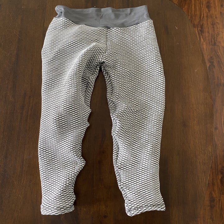 The front of the leggings, with a white-netted pattern on top of the gray, and a plain gray waistband