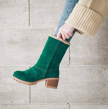 The green suede boot with it fully turned up to the mid-calf height