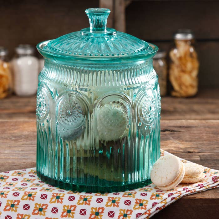 The cookie jar, which is a clear turquoise with pressed glass designs and a fully removable top