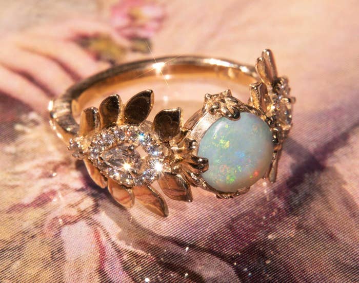 the ring with white diamond on one side and opal on the other joined by the gold band