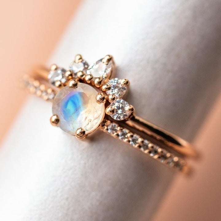 the ring with a white stone outer and an opal stone in the center