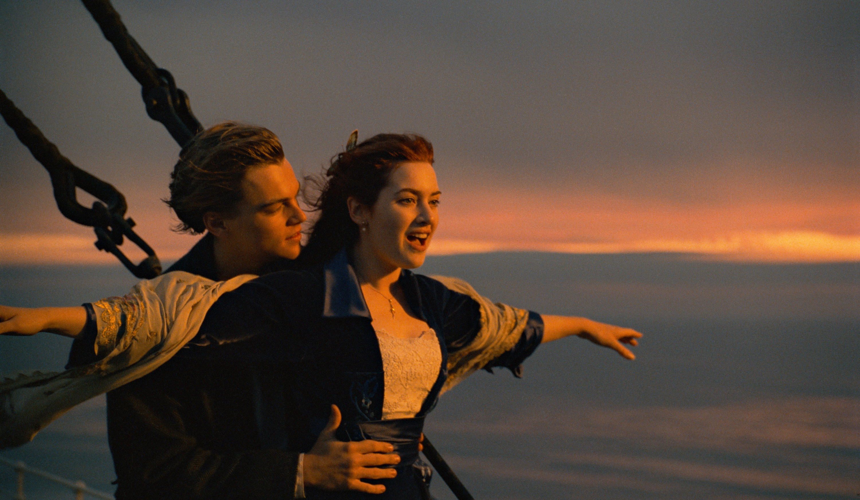 Leonardo DiCaprio holds Kate Winslet at the front of the Titanic with her arms outstretched in the film Titanic