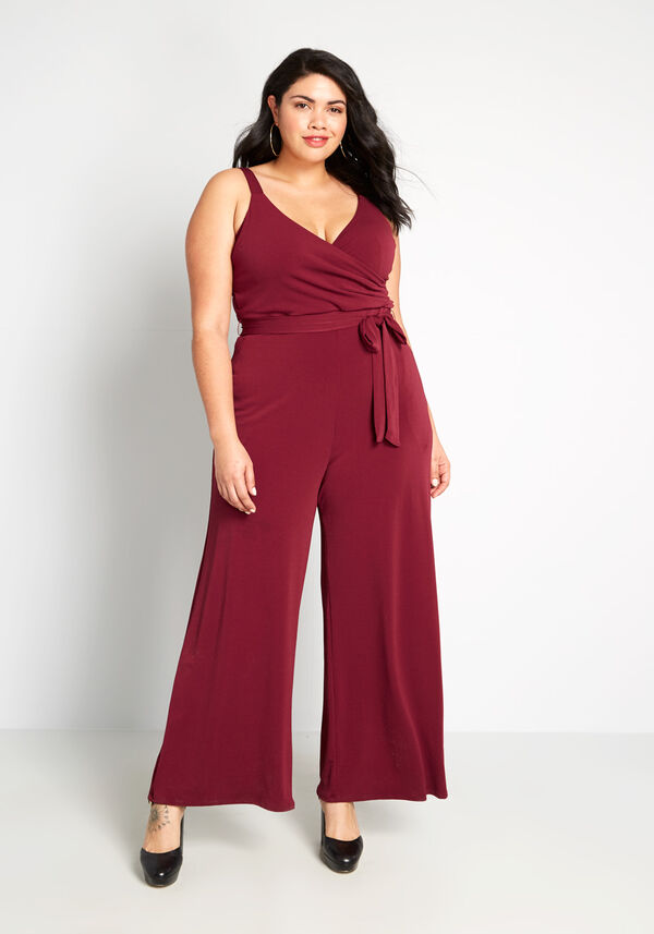 Model wearing the jumpsuit in red with a tied waist