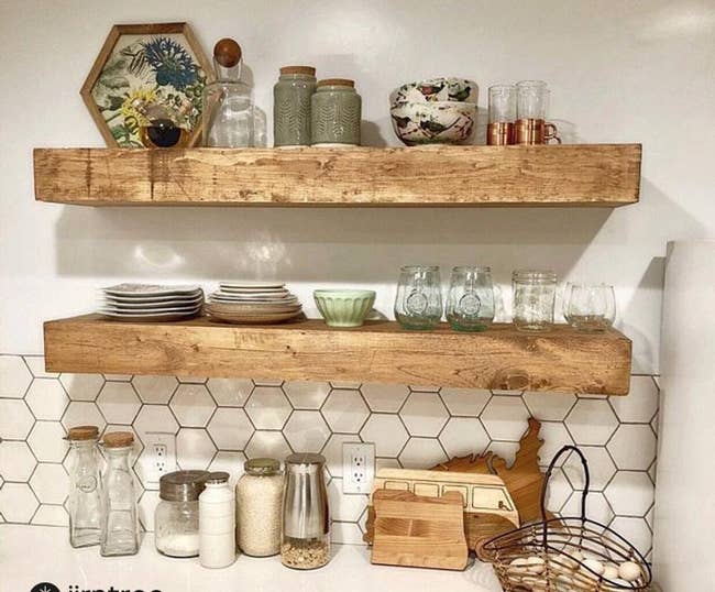 the wooden shelves hanging in a kitchen and holding things like dishes, cups, and decorative pieces