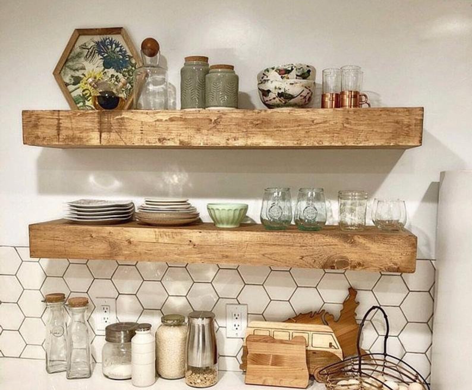 the wooden shelves hanging in a kitchen and holding things like dishes, cups, and decorative pieces