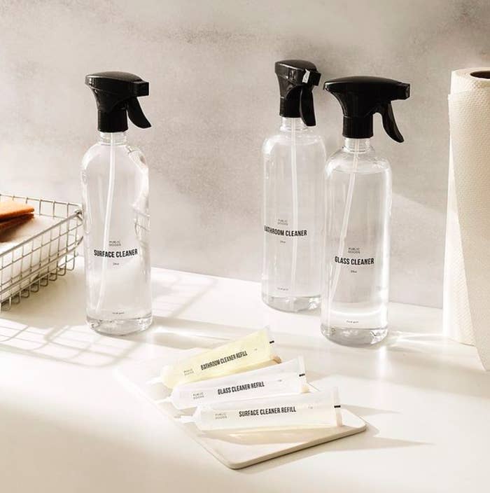 Clear bottles of cleaners upright on counter 