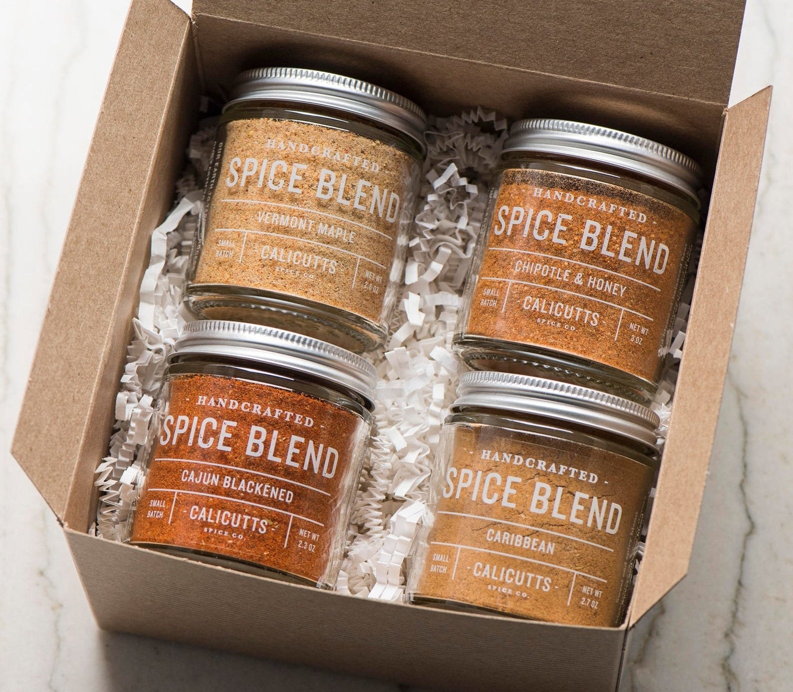 the four jars of spices that come in the pack — vermont maple, chipotle and honey, cajun blackened, and caribbean