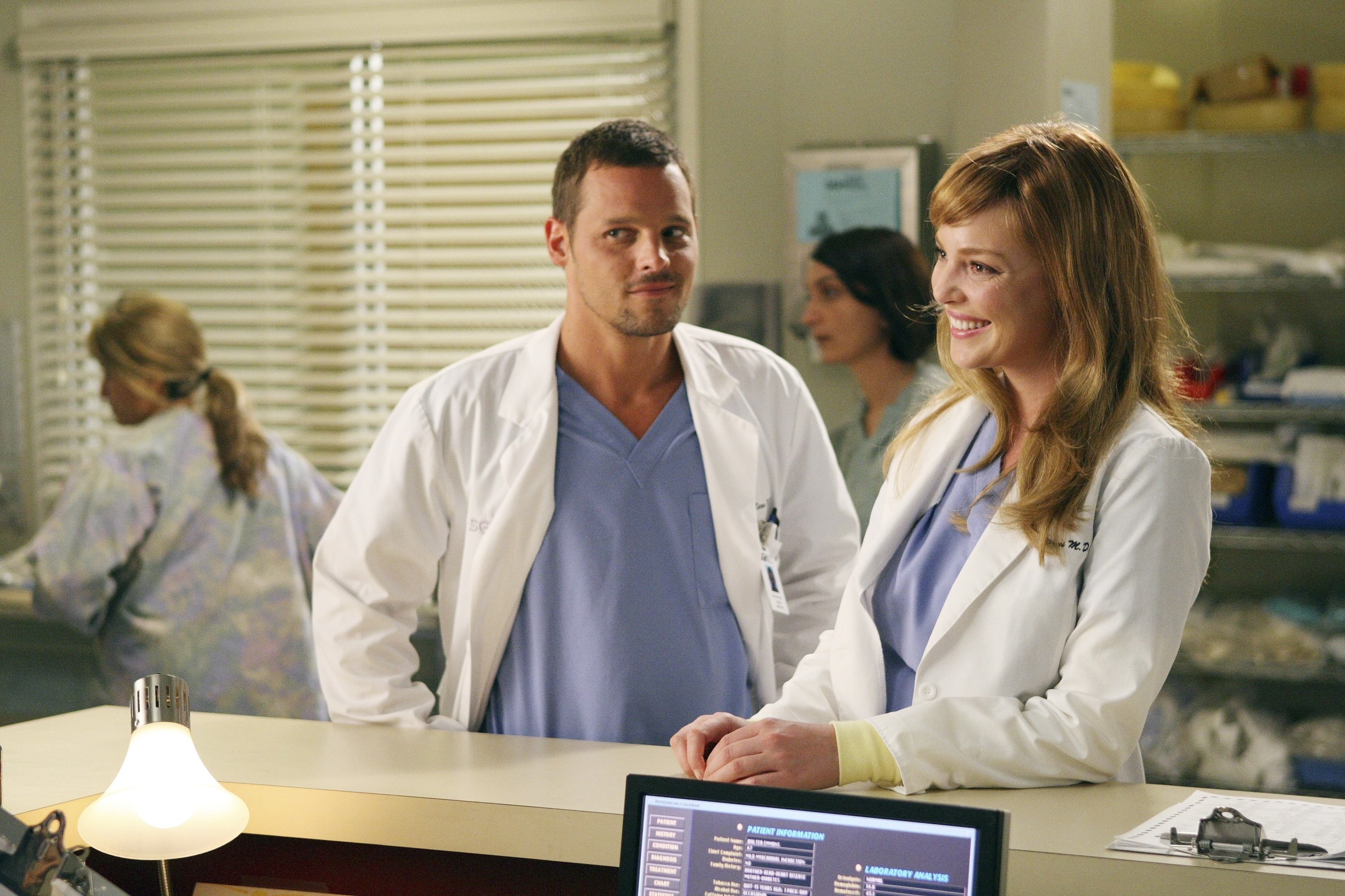 Justin Chambers and Katherine Heigl stand at a counter in Grey&#x27;s Anatomy