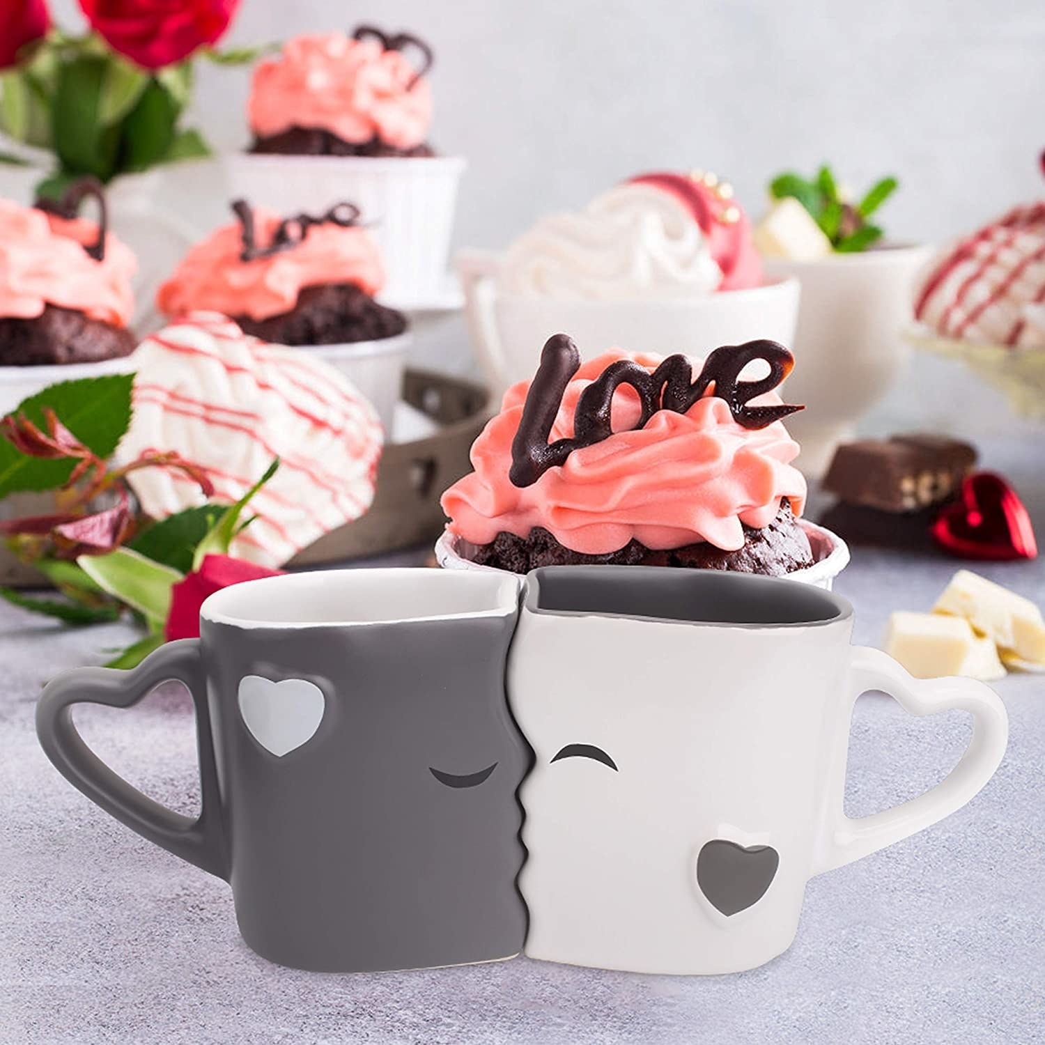 grey and white kissing mugs on a table surrounded by desserts