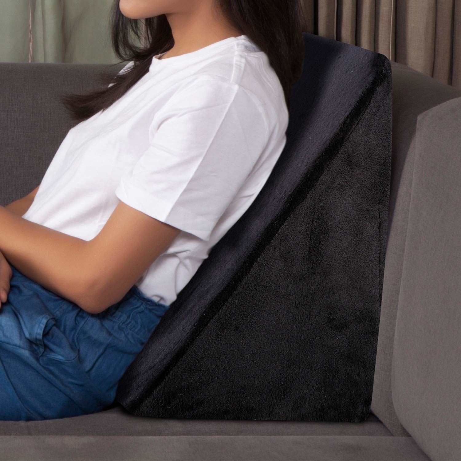 A woman leaning on a memory foam wedge pillow 