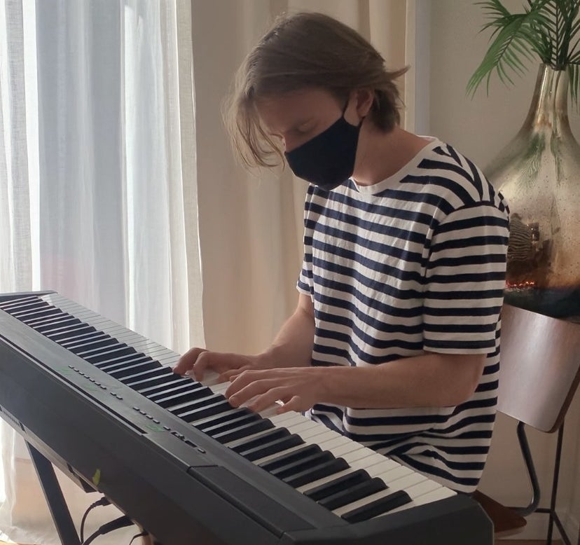 Stephen plays piano with a mask on