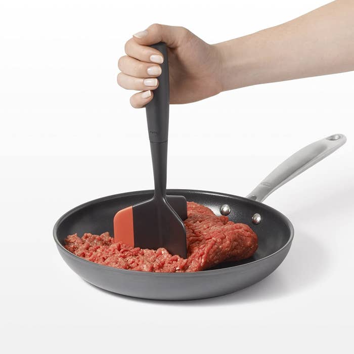 Person grinding meat with the chopping tool