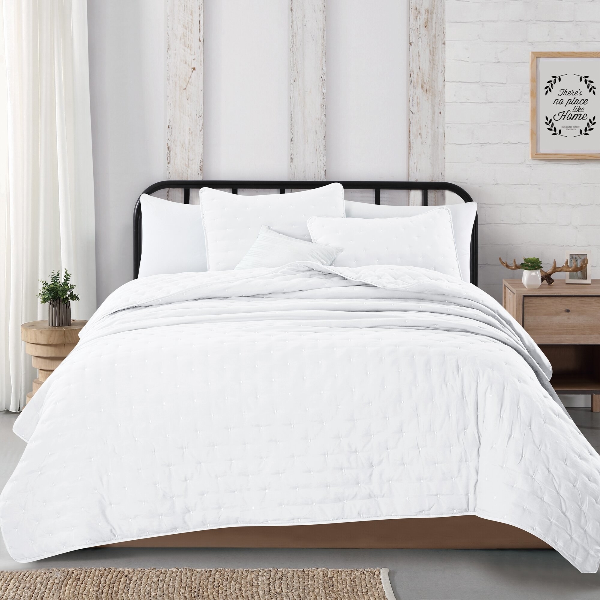 white stitch patterned quilt set on a bed