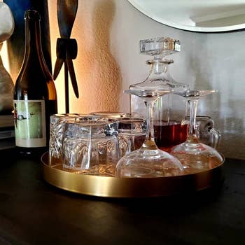 A reviewer using the gold tray to hold glasses and liquor bottles