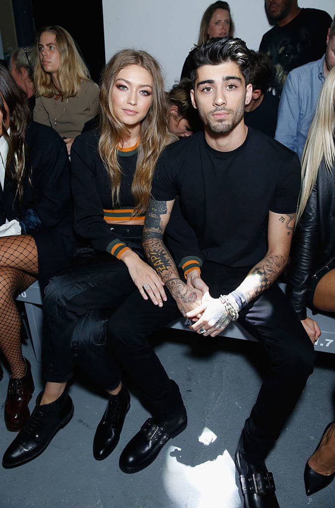 Gigi and Zayn sitting next to each other at the front show of a fashion show
