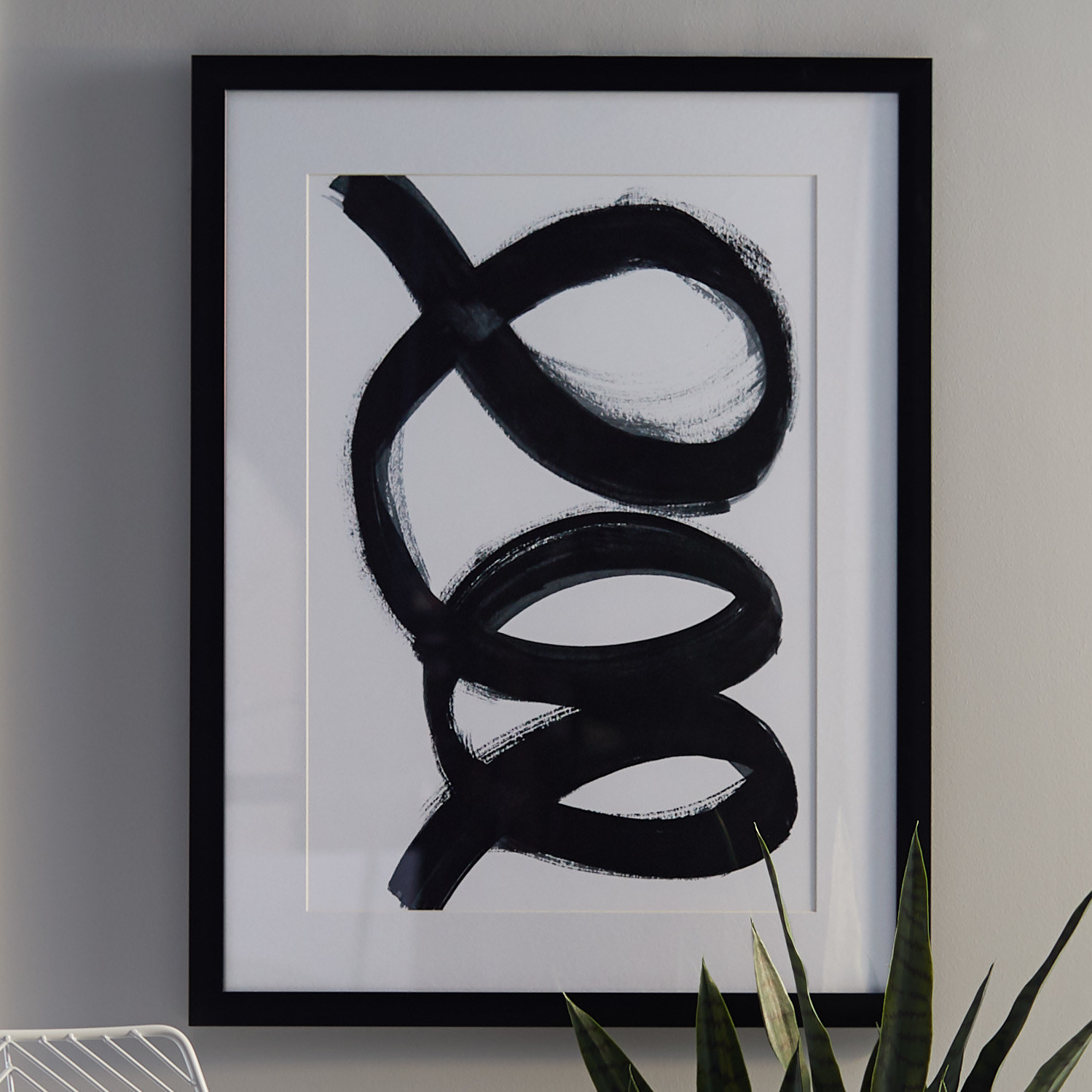a mordern black swirl print in a black frame