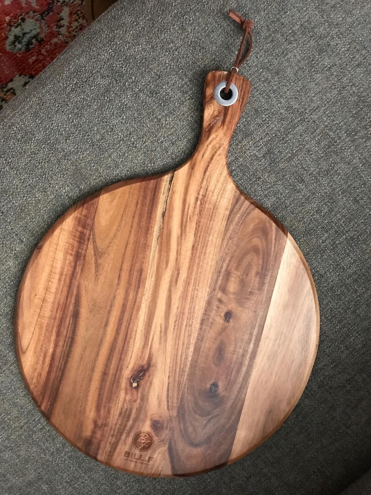 A reviewer&#x27;s photo of the wooden cheese paddle