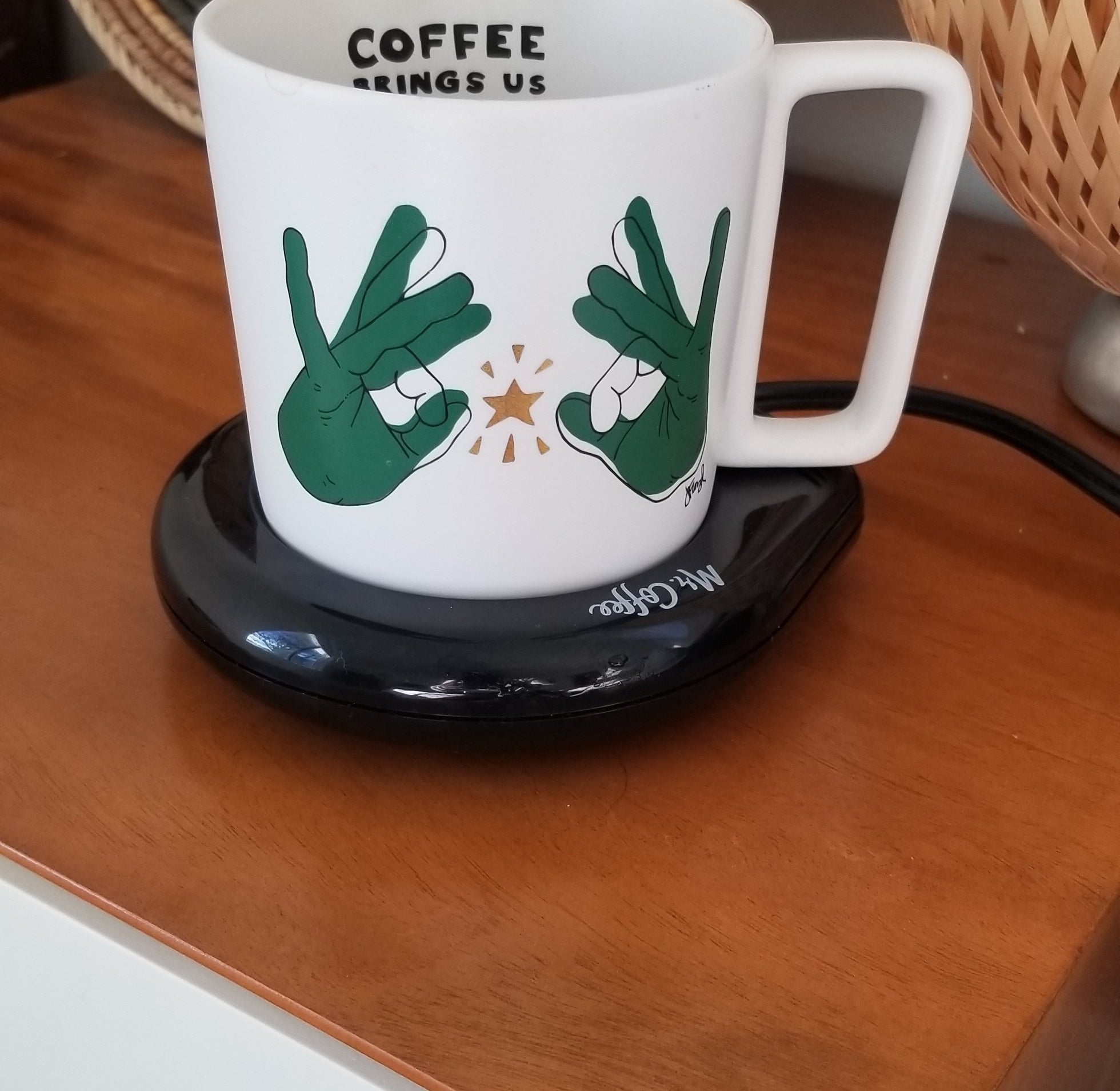 The mug warmer on a bedside table with mug on top