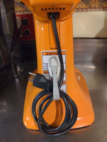 A reviewer's photo of the cord bundler attached to the back of a KitchenAid