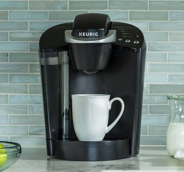 black keurig coffee machine with a white mug underneath