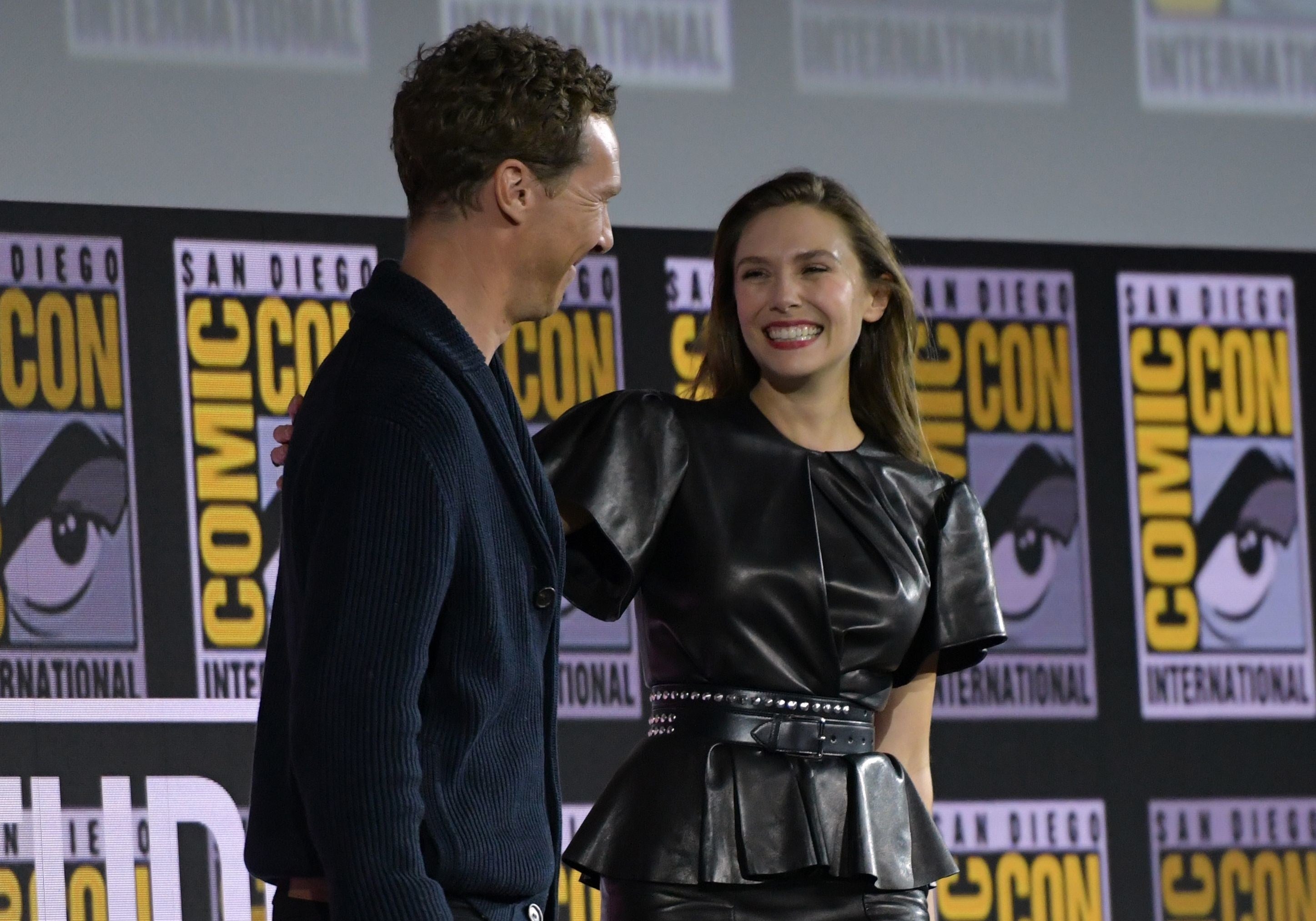 Elizabeth Olsen smiling at Benedict Cumberbatch, who plays Dr. Strange, at a ComicCon panel