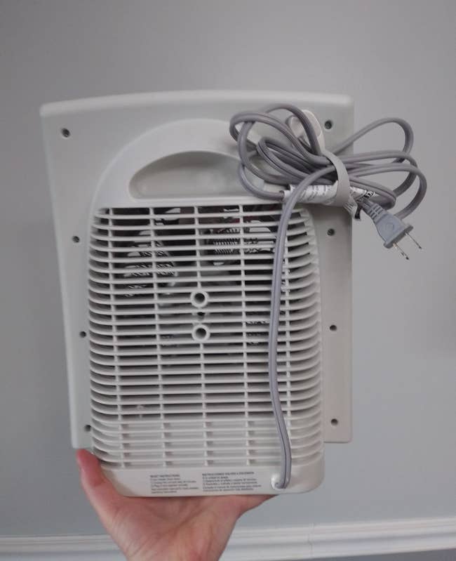 A reviewer's photo of the cord organizer being used on a small fan